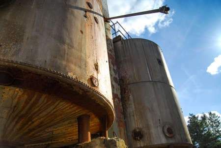 Old abandoned defaulted industrial building which stands with rusty and empty siloの写真素材