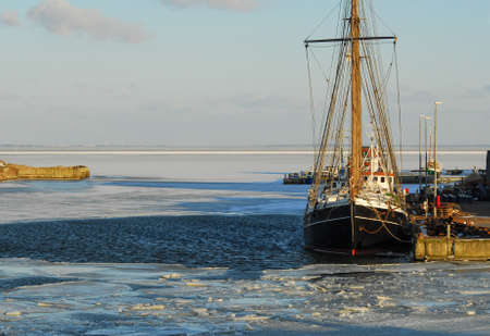 Black fishing boat is docked, while the waves shower. fishing trawlerの写真素材