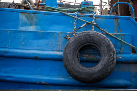 rubber tire against the boat, to protect the side of the ship to the quayの写真素材