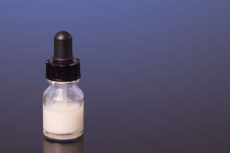 dropper bottle with milk white liquid, isolatedの写真素材