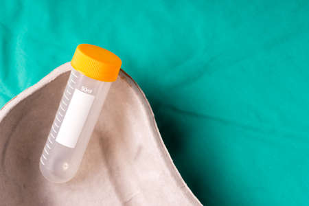 Medical test tube lying in a one use capsule on the hospital's green background. The background can...