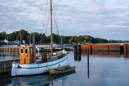 Harbor with little blue fisherboat with bright blue skyの写真素材