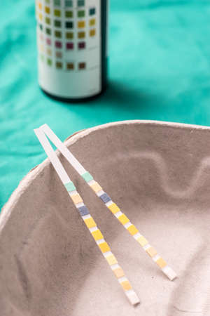 Medical Urine test strpis lying in a one use capsule on the hospital's green background. The background can be a textile part of a doctor or nurse's work uniformの写真素材