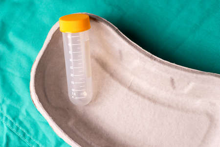 Medical test tube lying in a one use capsule on the hospital's green background. The background can be a textile part of a doctor or nurse's work uniformの写真素材