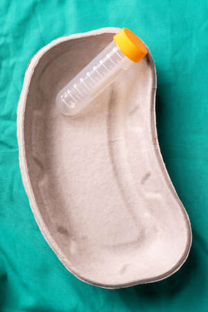 Medical test tube lying in a one use capsule on the hospital's green background. The background can...