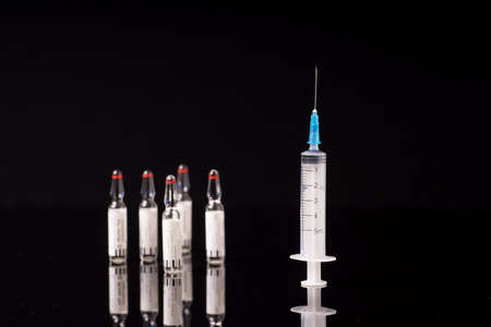 syringe and medical vials isolated on black backgroundの写真素材