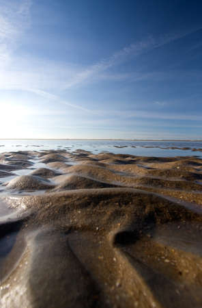 Brown Sand beach ending into the sea with bright horizon. の写真素材