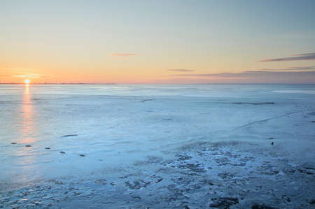 cold landscape on a frozen lake at sunset