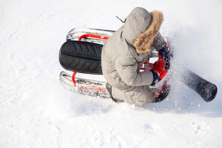 Winter sports  kid sleighing roughly down the slope