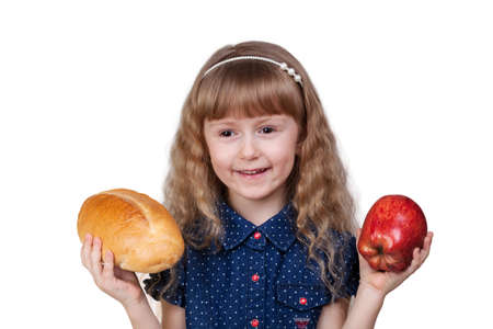 Adorable little smiling girl with red apple and bread isolated on white backgroundの写真素材