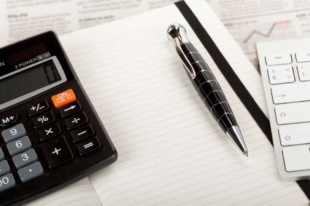 Business newspaper overview with open book, keyboard and calculator の写真素材