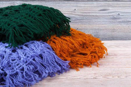Traditional knitted woolen female shawls on wooden background