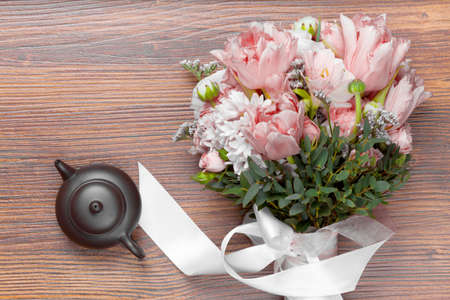 Amazing flower bouquet with ceramics tea pot on wooden backgroundの写真素材