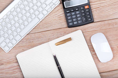 Business concept photo: keyboard, calculator, paper, ink pen on wooden background