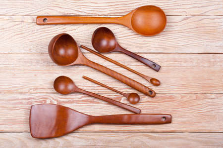 Assorted wooden tableware ladles and spoons on wooden tableの写真素材