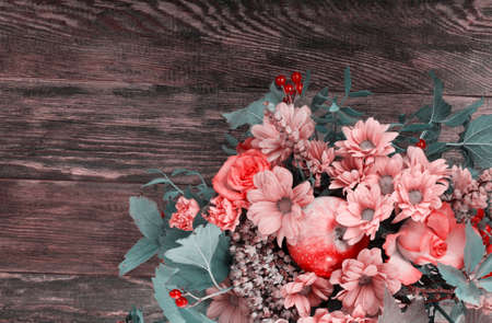 Amazing autumn bouquet with berries and apple on wooden background