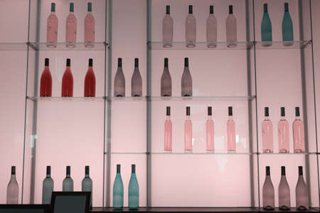 Shelves with colorful bottles of alcohol drinks. の写真素材