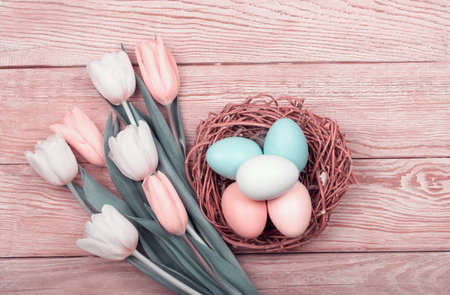 Easter Eggs in a box with colorful yellow tulips and pink ribbonの写真素材