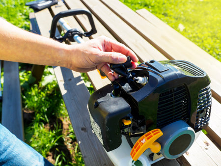 Hand of unrecognizable person checking the spark plug of a garden machine before starting work....