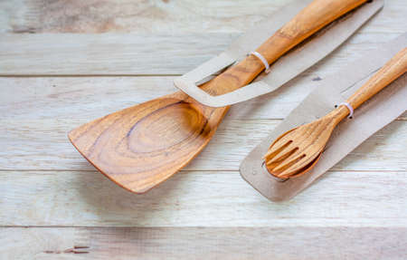 Wooden spoon and fork in package on table with selective focusing