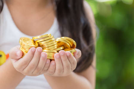 Hand holding golden coins concept on green background. Taxpayer business conceptの写真素材