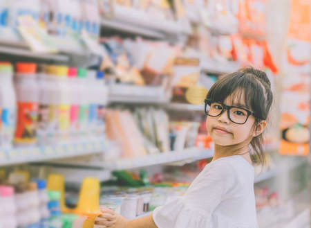 Girl at the shopping mall,Portrait of young girl at the shop standing near the shelves with sweetsの写真素材
