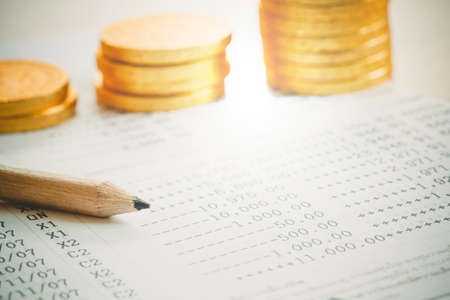 close up of pen with coins for loan money concept