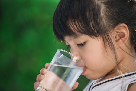 Little girl drinking waterの写真素材