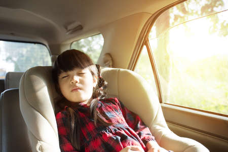 little girl sleeping in child car seatの写真素材