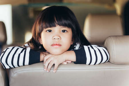 depressed Asian chinese child. Little girl showing her unhappy face in carの写真素材