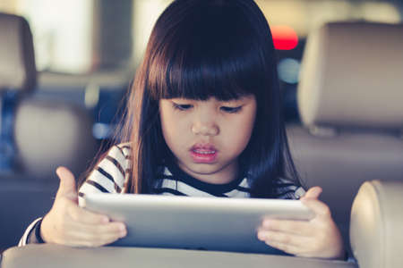 kid play Tablet in carの写真素材