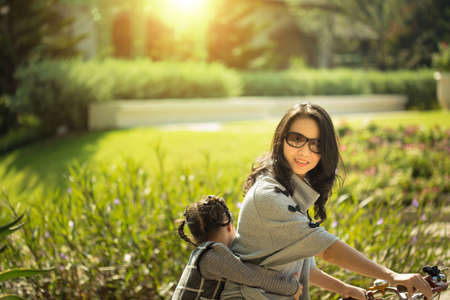 Mother and a daughter cycling bicycle at the parkの写真素材
