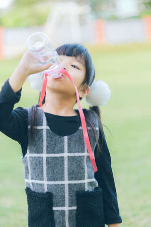 Kid drinking water from a bottleの写真素材
