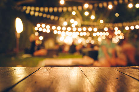 Image of wooden table in front of abstract blurred restaurant lights backgroundの写真素材