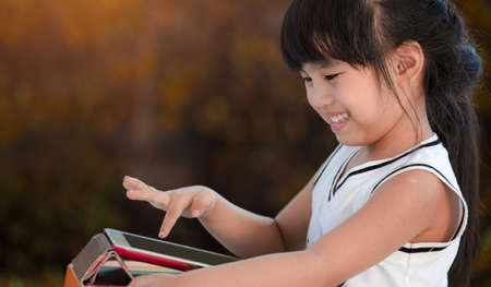 Young asian girl sitting ,playing with digital tablet
