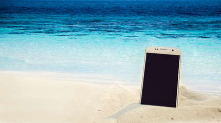 smartphone in the sand on a beach in the summerの写真素材