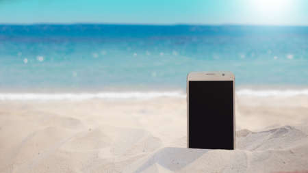 smartphone in the sand on a beach in the summerの写真素材