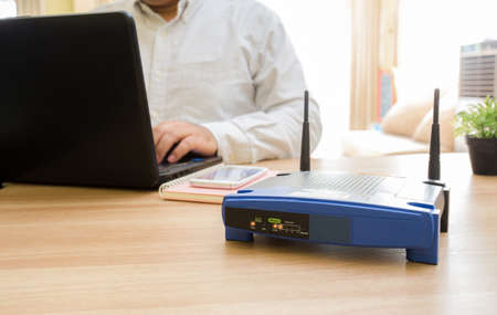 closeup of a wireless router and a man using Laptop and notebook computers on living room at home ofiiceの写真素材