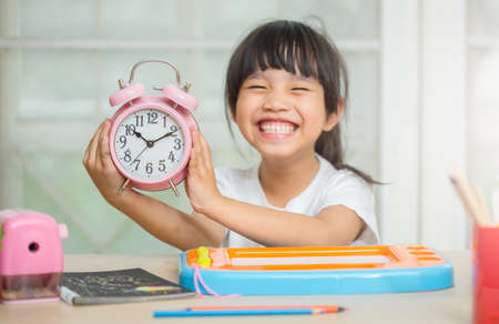 childhood and education concept - happy student girl preparing for school examsの写真素材
