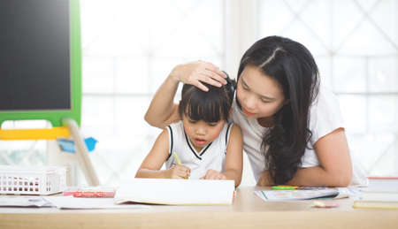 happy family , education concept - mother and daughter with chalk drawingの写真素材
