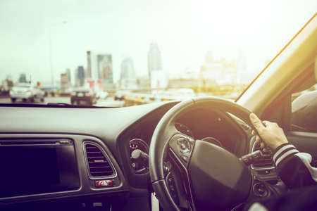 Female driving car view big city town blurred background.Vintage filterの写真素材
