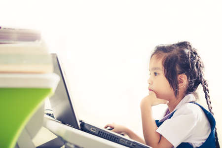 Little cute child playing with laptop at homeの写真素材