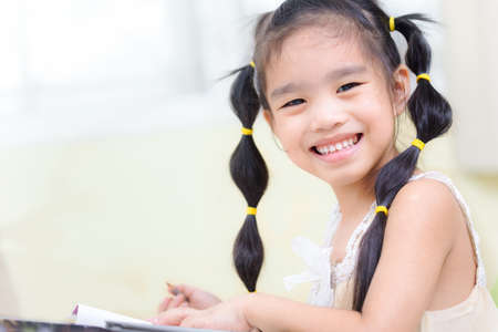 Cute little girl doing homework, reading a book,の写真素材