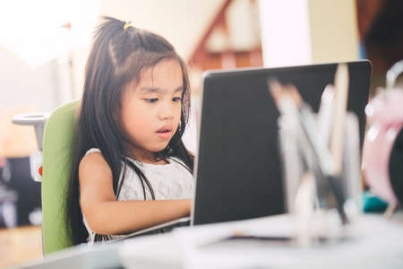 Technology and early education. Child use laptop for fun and learning.の写真素材