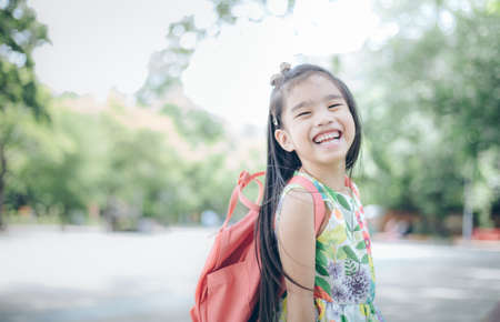 Happy asian girl arriving school from home with a backpackの写真素材
