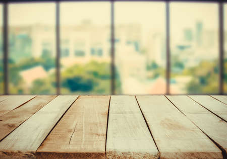 ooden table in front of abstract Blur white green background from office windowの写真素材