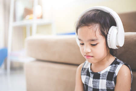 Happy  Asian girl using headphone for listen music by smartphone while  in the live roomの写真素材