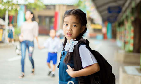 Happy asian girl arriving school from home with a backpackの写真素材