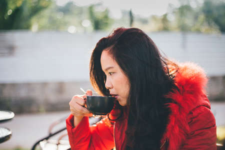 beautiful young woman drinking coffeeの写真素材