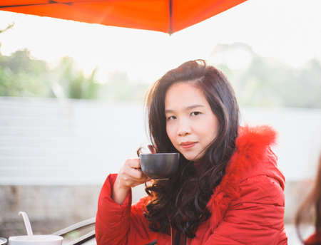 beautiful young woman drinking coffeeの写真素材